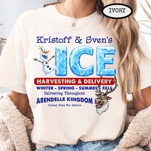 Op de afbeelding: Ivoor T-shirt met de blauwe tekst "Kristoff & Sven's ICE", met illustraties van Olaf en Sven. Het shirt bevat ook tekst over oogsten en levering in het hele koninkrijk Arendelle.