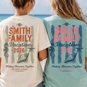 May include: Two short-sleeve t-shirts, one cream and one light green, featuring a back graphic with the text SMITH FAMILY Vacation 2026, Making Memories Together, and KEY WEST, FLORIDA, decorated with illustrations of a seahorse, starfish, and seashell.