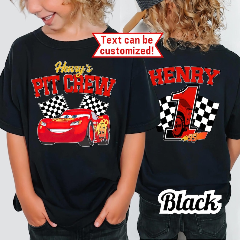 May include: Black t-shirt with a red cartoon race car and the text "Henry's PIT CREW" and checkered flags. The back of the shirt has the name "HENRY" in red, a number "1", and checkered flags. The text "Text can be customized!" is also visible.