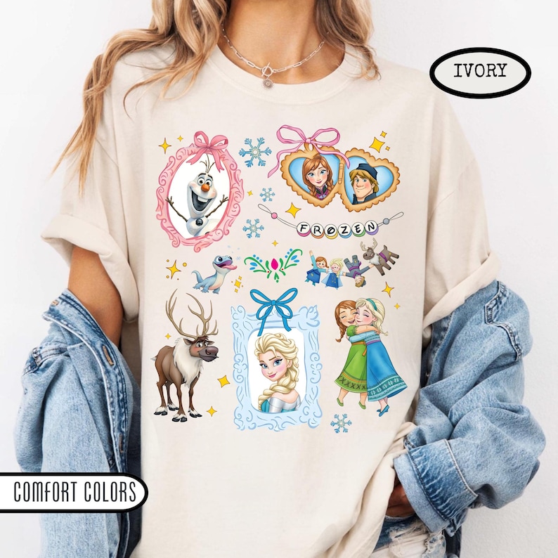 Puede incluir: Camiseta de color marfil con gr&aacute;ficos coloridos de personajes y elementos de la pel&iacute;cula animada "Frozen". El dise&ntilde;o incluye im&aacute;genes de Olaf, Anna, Elsa, Kristoff y Sven, junto con la palabra "FROZEN".