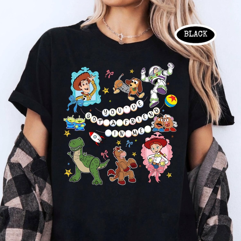 May include: Black t-shirt featuring colorful cartoon characters and the text "You've Got a Friend in Me." The design includes Woody, Buzz Lightyear, and other characters from the animated movie.