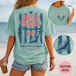 May include: A seafoam green t-shirt featuring a back graphic with vertical blue stripes, a seahorse, a starfish, and a seashell. The text reads SMITH FAMILY Vacation 2026 Making Memories Together KEY WEST FLORIDA. A front chest logo shows palm trees.