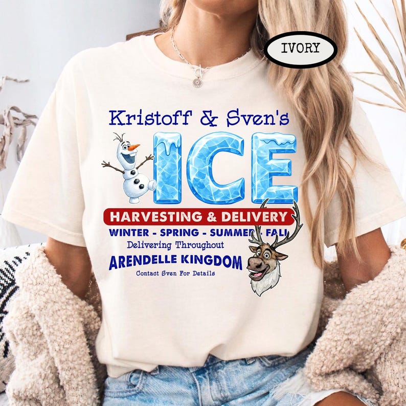 Op de afbeelding: Ivoor T-shirt met de blauwe tekst "Kristoff & Sven's ICE", met illustraties van Olaf en Sven. Het shirt bevat ook tekst over oogsten en levering in het hele koninkrijk Arendelle.