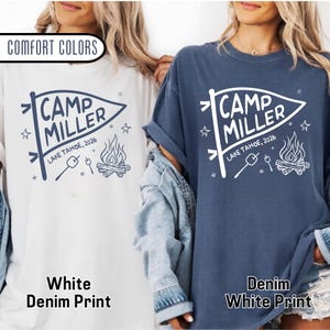 May include: A white t-shirt and a denim blue t-shirt, both featuring a graphic print of a pennant flag with the text CAMP MILLER LAKE TAHOE, 2026, a campfire, and marshmallows on sticks. The text COMFORT COLORS is visible in the top left corner.