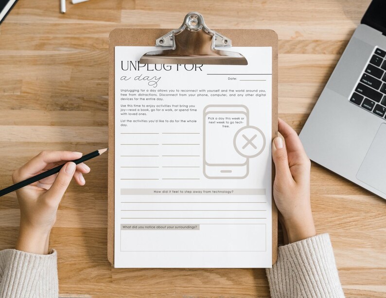 Peut inclure: Un presse-papiers avec une feuille de travail imprim&eacute;e intitul&eacute;e &laquo;&nbsp;D&eacute;connectez-vous pour une journ&eacute;e&nbsp;&raquo; est pos&eacute; sur une surface en bois. La feuille de travail comprend des invites pour lister les activit&eacute;s et r&eacute;fl&eacute;chir &agrave; la d&eacute;connexion de la technologie. Un ordinateur portable et un crayon sont &eacute;galement visibles.