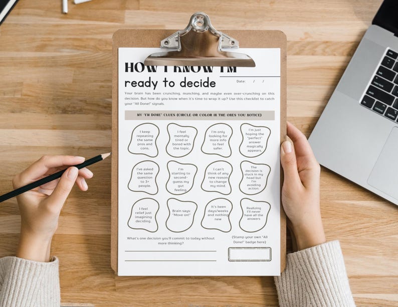 May include: A clipboard with a printed worksheet titled "HOW I KNOW I'M ready to decide." The worksheet includes prompts for self-reflection and decision-making. A laptop and pencil are also visible.