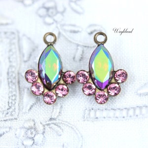 Könnte beinhalten: Ein Paar antike goldfarbene Ohrring-Anhänger mit einem großen, schillernden, tropfenförmigen Kristall und einer Gruppe kleinerer rosa Kristalle.