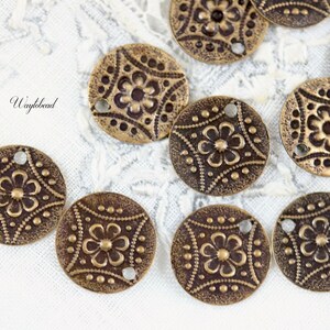 May include: A collection of 10 antique brass metal charms with a floral design. Each charm has a hole for attaching to a necklace, bracelet, or other jewelry project.