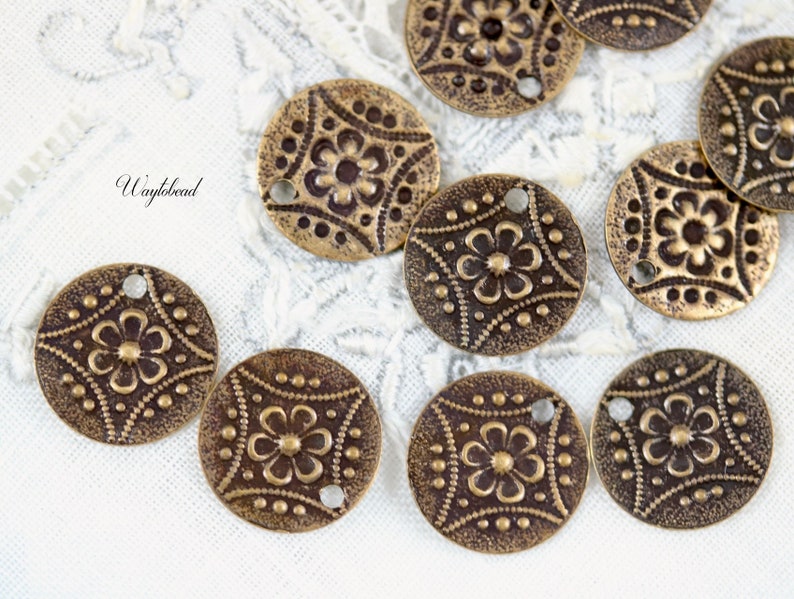 May include: A collection of 10 antique brass metal charms with a floral design. Each charm has a hole for attaching to a necklace, bracelet, or other jewelry project.
