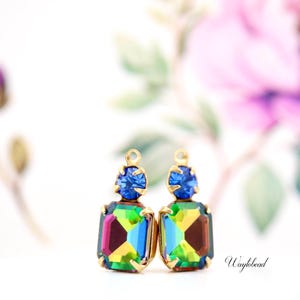 Puede incluir: Un par de pendientes de oro con una piedra preciosa azul y una piedra preciosa más grande, iridiscente y multicolor.