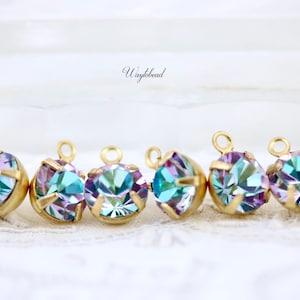 Può includere: Sei ciondoli in metallo dorato con strass blu e viola iridescenti. Ogni ciondolo ha un anello in cima per essere attaccato a gioielli o altri oggetti artigianali.