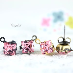 May include: Four pairs of pink square crystal earrings with different earring backs. The earrings have a silver tone and gold tone finish.