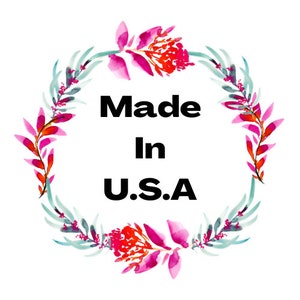 May include: A watercolor wreath of pink and green flowers with the text "Made in U.S.A." in the center.