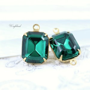 May include: Two emerald green glass square-shaped pendant charms with gold-toned metal settings and loops.