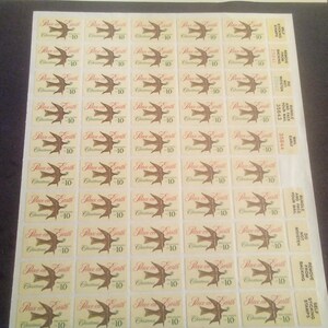 May include: Sheet of vintage postage stamps featuring a brown bird in flight design. Each stamp has the text "Peace on Earth Christmas" and a value of "10". The stamps are on a white background.