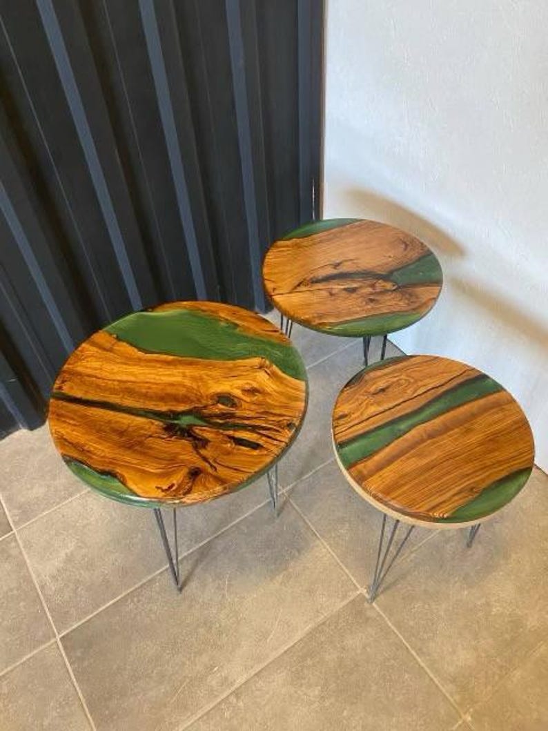 May include: Three round wooden tables with green epoxy resin inlays. The tables have black metal hairpin legs.