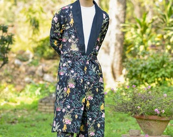 May include: A black and green patterned robe with a long sleeve and a sash. The robe has a floral and animal print.