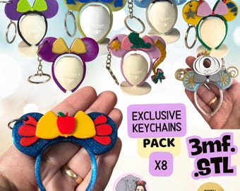 May include: A collection of eight character-themed ear headbands designed as keychains, featuring various colors and motifs including bows, crowns, and icons. The image includes text reading Exclusive Keychains Pack X8, 3mf. STL, and Digital Download.