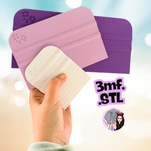 May include: Three rectangular craft squeegees in varying sizes and colors, including dark purple, light lavender, and white. Each tool features a molded flower design in the corner and horizontal ridges along the surface. Text reads 3mf. .STL.