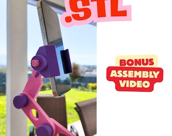May include: A pink and purple phone stand with a phone attached. The stand has adjustable joints and a phone holder. The image includes the text ".STL" in pink and the text "BONUS ASSEMBLY VIDEO" in red and yellow.