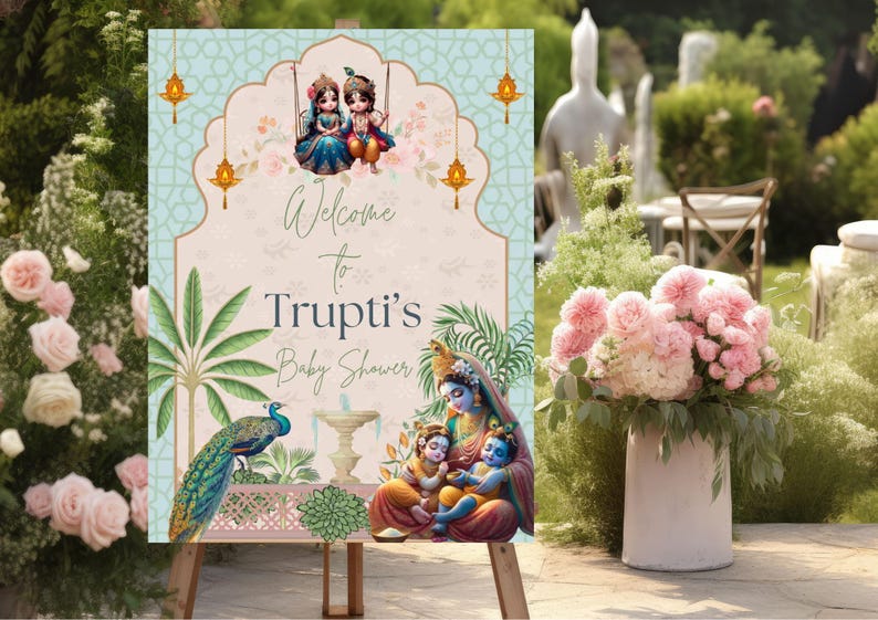May include: A welcome sign for a baby shower with a blue and green floral design. The sign features a peacock, a fountain, and a family of three figures. The text on the sign reads "Welcome to Trupti's Baby Shower".