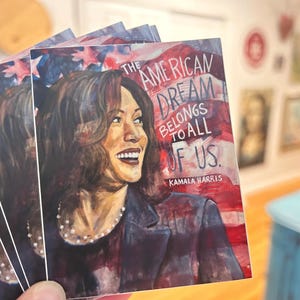 May include: A sticker featuring a portrait of Kamala Harris with the text "The American Dream Belongs To All Of Us." The background is a red, white, and blue American flag.