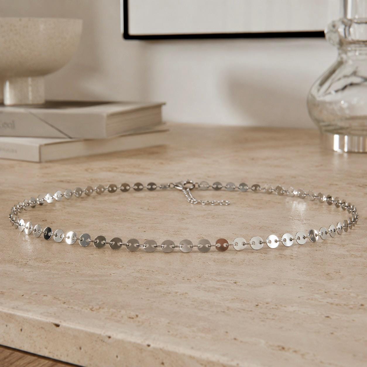 Silver-tone stainless steel chain waist belt draped over dress for minimalist body jewelry styling
