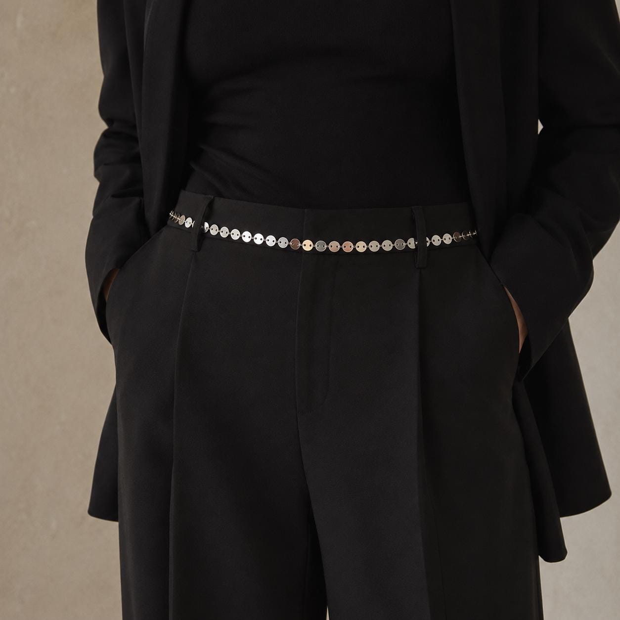 Silver-tone stainless steel chain waist belt draped over dress for minimalist body jewelry styling