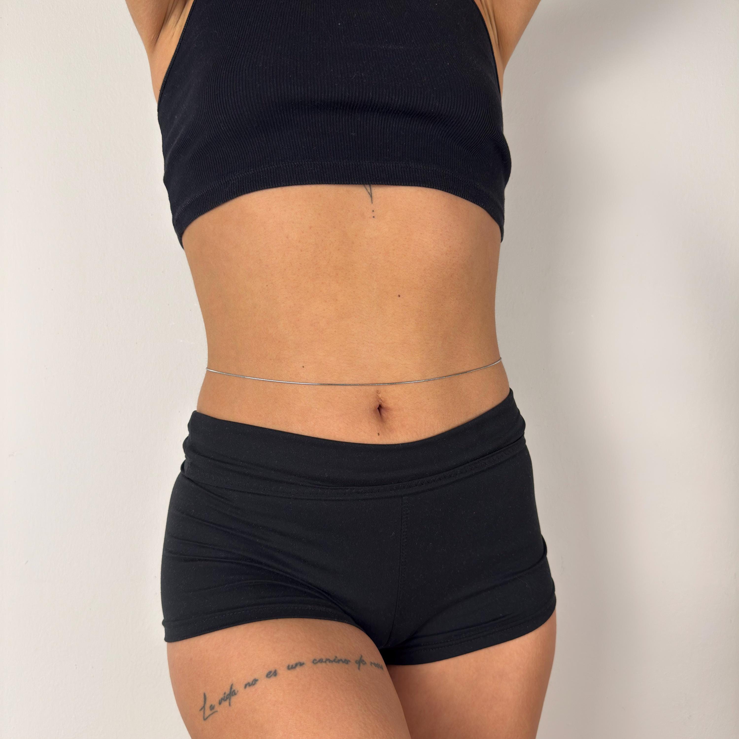 Gold tone stainless steel snake belly chain draped on waist, minimalist summer jewelry accessory