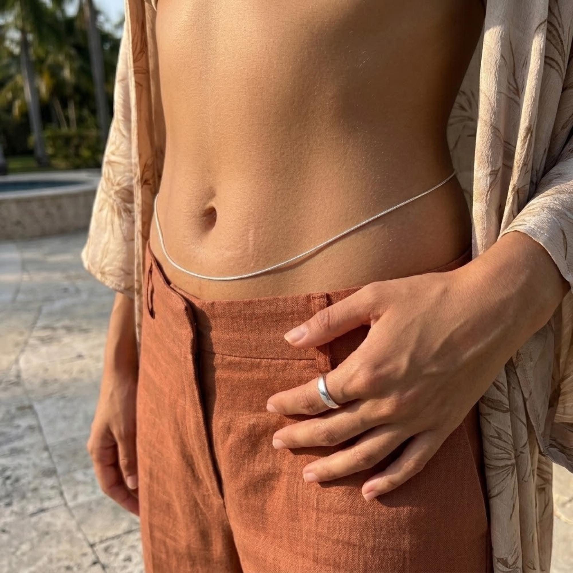 Minimalist silver-tone stainless steel belly body chain for beach wear, water-resistant and adjustable.