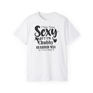 Puede incluir: Camiseta blanca con texto negro: "I Hate Being Sexy BUT I'M A Chubby Bearded Man So I Can't Help It." La camiseta tiene cuello redondo y mangas cortas.