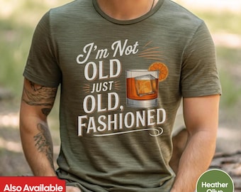Puede incluir: Una camiseta verde con el texto "I'm Not Old Just Old, Fashioned" y un gráfico de un cóctel old fashioned.