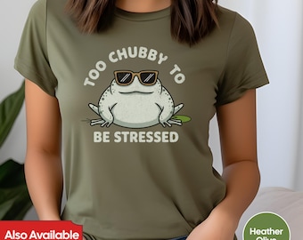 May include: A green t-shirt with a cartoon frog wearing sunglasses and the text "Too Chubby To Be Stressed".