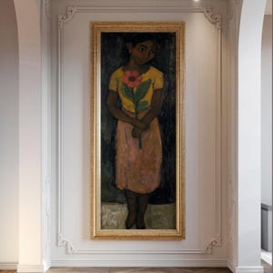 Peut inclure: Tableau encadré d'une femme tenant une fleur. La femme porte un haut jaune et une jupe rose. Le tableau est dans un cadre doré et est accroché à un mur blanc.