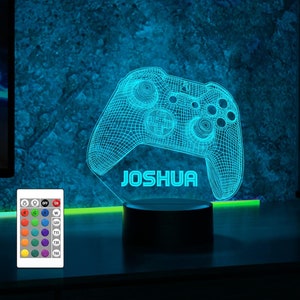 May include: A blue 3D printed gamer controller night light with the name "JOSHUA" printed below it. The light is on a black base and has a remote control with multiple color options.