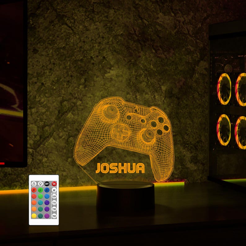 May include: A yellow 3D printed gamer controller night light with the name "Joshua" printed below it. The light is on a black base and has a remote control with multiple colored lights.