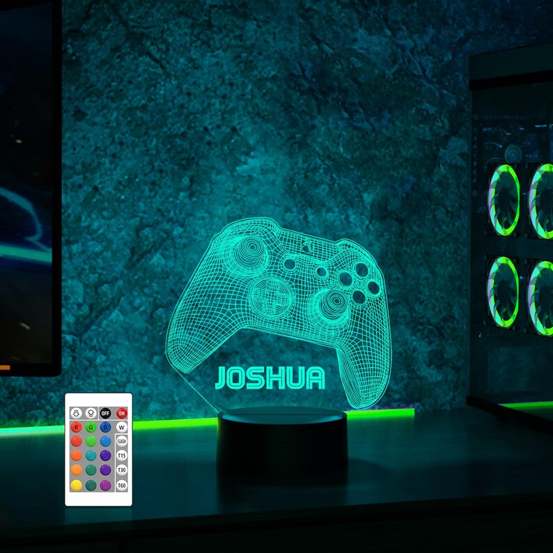 May include: A green and black 3D printed gamer controller night light with the name "Joshua" on the base. The light is on a black base and has a remote control with multiple color options.