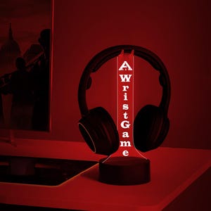 May include: A black and red LED night light shaped like a headphone stand with the word "Wrist Game" written vertically on the front.