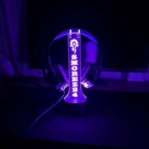 May include: A purple LED light stand with a headset holder. The stand has the name "SMOREZZ24" and a symbol on it.