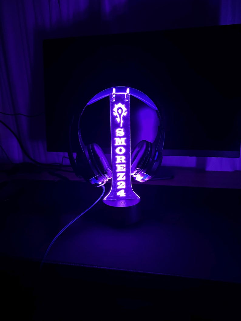 May include: A purple LED light stand with a headset holder. The stand has the name "SMOREZZ24" and a symbol on it.