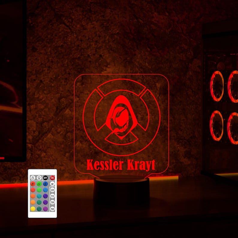 May include: A red LED night light with a hooded figure design and the text "Kessler Krayt". The light is on a black base and has a remote control with multiple color options.