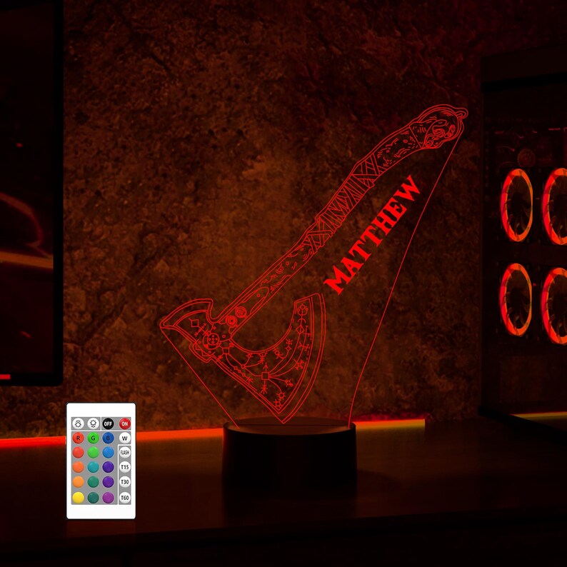 May include: A red LED night light shaped like an axe with intricate details. The name "MATTHEW" is written on the axe. The light is on a black base and is controlled by a remote.