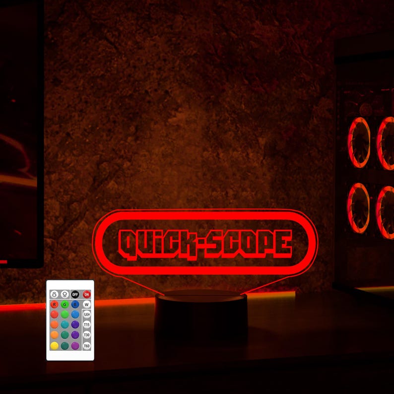 May include: Red LED light with a black base and a remote control. The light features a red neon sign that says "QUICK-SCOPE".