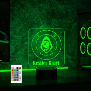May include: A green LED night light with a custom design featuring a hooded figure and the text "Kessler Krayt". The light is on a black base and has a remote control with multiple color options.