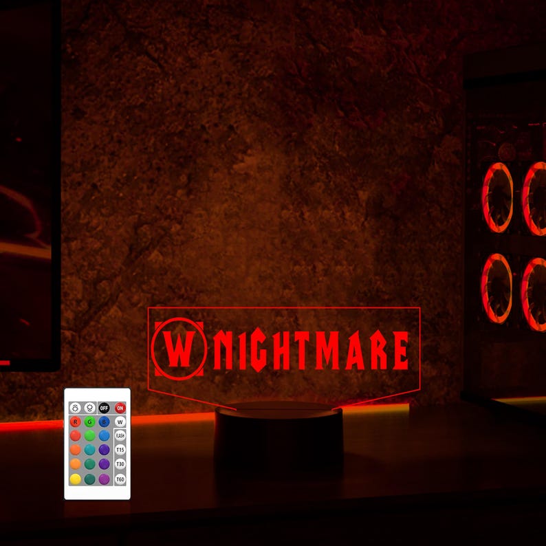 May include: A red LED light with a black base, displaying the text "W NIGHTMARE" in a white circle. The light is on a table with a remote control nearby.