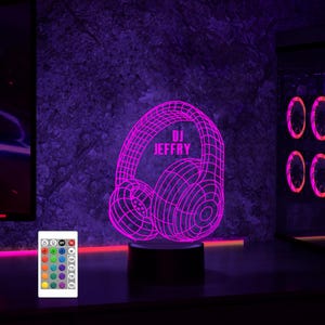 May include: A pink 3D printed LED night light shaped like headphones with the text "DJ JEFFRY" on the side. The light is on a black base and has a remote control with multiple color options.