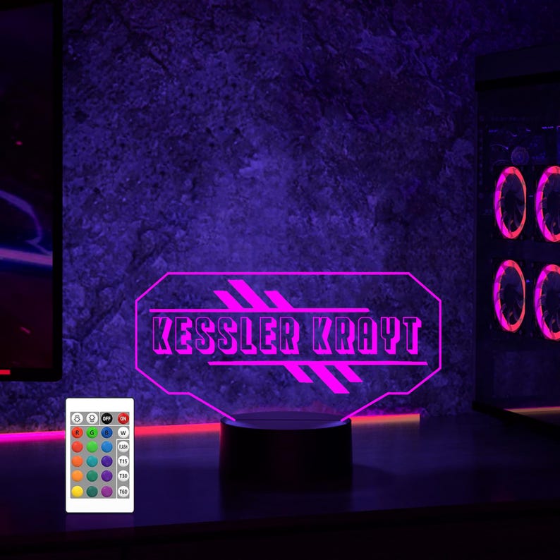Pu&ograve; includere: Una luce LED viola con un design personalizzato che dice "Kessler Krayt". La luce &egrave; su una base nera e ha un telecomando con pi&ugrave; opzioni di colore.