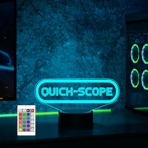 May include: A blue neon sign with the text "QUICK-SCOPE" on a black base. The sign is illuminated and has a remote control with multiple color options.