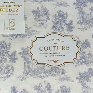 May include: A clear document folder with a blue and white toile de Jouy pattern. The folder has a label that says "CLEAR DOCUMENT FOLDER" and "A4 size, 3 pockets". A second label reads "L'ENCYCLOPEDIE des COUTURE".