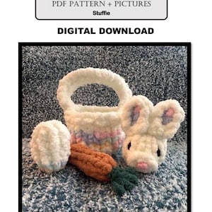 May include: A crochet Easter set including a white rabbit head, a basket with pastel stripes, a carrot, and an egg. The set is made of fluffy yarn. The image text reads "MINI RABBIT + BASKET + CARROT + EGG" and "DIGITAL DOWNLOAD".